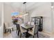 Elegant dining room with modern chandelier, and large windows with views of the landscaped yard at 12736 Penguin Dr, Bradenton, FL 34212