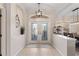 Bright foyer with decorative glass double doors, tiled floors, transom window, and elegant light fixture at 12736 Penguin Dr, Bradenton, FL 34212