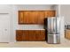 Bright kitchen with stainless steel refrigerator and wooden cabinetry, offering ample storage at 12736 Penguin Dr, Bradenton, FL 34212