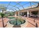 A beautiful screened-in pool and spa area with a spacious patio and outdoor dining set at 12736 Penguin Dr, Bradenton, FL 34212