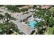 Overhead shot of a community clubhouse and pool surrounded by lush greenery and tropical palm trees at 12803 Coastal Breeze Way, Bradenton, FL 34211