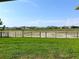 Backyard view showcasing well-manicured lawn, a black metal fence, and neighboring homes for a sense of community at 13393 Golden Lime Ave, Spring Hill, FL 34609