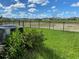 Nice backyard view featuring lush green lawn, black metal fence, community space, and landscaping at 13393 Golden Lime Ave, Spring Hill, FL 34609