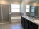 Bright bathroom features a soaking tub, glass-enclosed shower, and dual sink vanity with granite countertop at 13393 Golden Lime Ave, Spring Hill, FL 34609