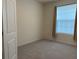 Bright, carpeted bedroom with large window and neutral-colored curtains at 13393 Golden Lime Ave, Spring Hill, FL 34609