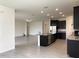 Kitchen with stainless steel appliances, dark wood cabinets, and a large island with granite countertop at 13393 Golden Lime Ave, Spring Hill, FL 34609