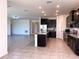 Kitchen with stainless steel appliances, dark wood cabinets, and a large island with granite countertop at 13393 Golden Lime Ave, Spring Hill, FL 34609