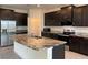 A kitchen with dark cabinets, granite countertops, stainless steel appliances, and an island at 13393 Golden Lime Ave, Spring Hill, FL 34609