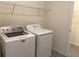 Bright laundry room featuring a washer, dryer, wire shelving, and access to additional storage or utility space at 13393 Golden Lime Ave, Spring Hill, FL 34609