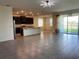 Bright, open living area with tile flooring, dark cabinets and a view to the patio through sliding glass doors at 13393 Golden Lime Ave, Spring Hill, FL 34609