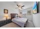 Comfortable bedroom with ceiling fan, gray plaid bedding, side tables and mounted TV at 13414 Sunset Sapphire Ct, Parrish, FL 34219