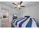 Bright bedroom featuring a ceiling fan and a TV atop a dresser with blue and white striped bedding at 13414 Sunset Sapphire Ct, Parrish, FL 34219