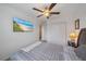 Well-lit bedroom featuring a ceiling fan, closet and a TV playing ocean scenery at 13414 Sunset Sapphire Ct, Parrish, FL 34219