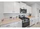 Updated kitchen featuring stainless steel appliances, white cabinets, and a stylish tile backsplash at 13414 Sunset Sapphire Ct, Parrish, FL 34219