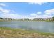 Picturesque lake view surrounded by well-maintained homes under a blue sky dotted with fluffy clouds at 13414 Sunset Sapphire Ct, Parrish, FL 34219