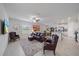 Open concept living room with modern furniture, ceiling fan and large windows at 13414 Sunset Sapphire Ct, Parrish, FL 34219