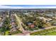 Aerial view of a residential area featuring homes with well-maintained lawns, a nearby lake, and mature trees at 1354 Lucaya Ave, Venice, FL 34285