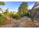 A backyard sitting area featuring a wooden bench and stone walking path surrounded by lush landscaping at 1354 Lucaya Ave, Venice, FL 34285