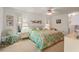 Bright bedroom featuring a floral comforter, ceiling fan, and natural light from the windows at 1354 Lucaya Ave, Venice, FL 34285