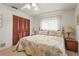 A quaint bedroom with floral bedding, wood closet doors, and matching bedside tables with lamps at 1354 Lucaya Ave, Venice, FL 34285