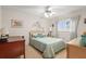 A cozy bedroom featuring floral accents, a ceiling fan, and a large window with natural light at 1354 Lucaya Ave, Venice, FL 34285