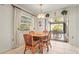 Cozy dining area featuring a round wood table, seating for four, and a bright, screened patio beyond sliding glass doors at 1354 Lucaya Ave, Venice, FL 34285