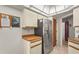 Kitchen area with stainless steel refrigerator, white cabinets, and a wooden door leading to another room at 1354 Lucaya Ave, Venice, FL 34285