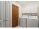 A compact laundry room featuring a white washer and dryer, white cabinets, and a closet for storage at 1354 Lucaya Ave, Venice, FL 34285