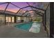 Twilight view of the home's serene pool with its screened enclosure offers privacy with mature trees at 1354 Lucaya Ave, Venice, FL 34285