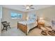 Bright bedroom featuring light wood floors, a cozy bed, and a view of lush greenery through the windows at 137 Avenida Messina # 3, Sarasota, FL 34242