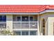 The condo's enclosed front porch, with a red tiled roof, arched entryway, and the security of screen enclosure at 137 Avenida Messina # 3, Sarasota, FL 34242