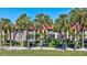 Attractive condo with a red tiled roof, large windows, and surrounded by lush palm trees and green grass at 137 Avenida Messina # 3, Sarasota, FL 34242