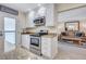 Charming kitchen with stainless appliances, white cabinets, granite counters and a view to living room at 137 Avenida Messina # 3, Sarasota, FL 34242