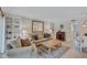 Inviting living room with built-in bookshelves, large mirror, comfortable seating, and a dining area at 137 Avenida Messina # 3, Sarasota, FL 34242