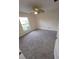 Bright bedroom featuring neutral carpet, ceiling fan, and natural light from the exterior window at 1402 Jakway Rd, North Port, FL 34288