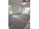 Bright bedroom with neutral carpet, ceiling fan, and exterior windows at 1402 Jakway Rd, North Port, FL 34288