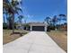 Inviting single-story home with a long driveway and attached garage, set against a blue sky at 1402 Jakway Rd, North Port, FL 34288