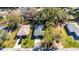 Aerial view showcasing a home with a well-maintained lawn and driveway, bordered by mature trees and green space at 1410 24Th E Ave, Bradenton, FL 34208