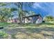 Rear exterior view of a cozy home featuring a shaded yard at 1410 24Th E Ave, Bradenton, FL 34208