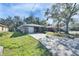 Single-story home with a front lawn, mature trees, and a long driveway at 1410 24Th E Ave, Bradenton, FL 34208