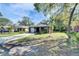 A cozy home with a lush green lawn, mature trees, and a long concrete driveway at 1410 24Th E Ave, Bradenton, FL 34208