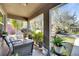 Covered front porch with outdoor seating area, plants, and a view of the surrounding neighborhood at 1410 24Th E Ave, Bradenton, FL 34208