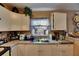 Close-up of a kitchen sink area with white cabinets and window at 1410 24Th E Ave, Bradenton, FL 34208