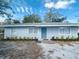 Charming single-story home with a well-manicured yard and blue front door at 1421 8Th E Ave, Bradenton, FL 34208