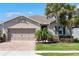 Beautiful single-story home with a brick driveway, a well-kept lawn and mature palm trees in landscaped front yard at 14355 59Th E Cir, Bradenton, FL 34211