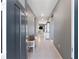 Inviting hallway with modern gray walls, decorative bench, and tile flooring that leads into an open-concept home at 14355 59Th E Cir, Bradenton, FL 34211