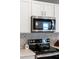 Close-up of modern stainless steel microwave and electric stovetop, framed by a decorative backsplash at 14355 59Th E Cir, Bradenton, FL 34211