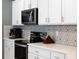 Stainless steel appliances and white cabinets in a modern kitchen with decorative backsplash at 14355 59Th E Cir, Bradenton, FL 34211