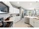 Open kitchen with stainless steel appliances, an island, and a view into the living area at 14355 59Th E Cir, Bradenton, FL 34211