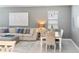 An open-concept living and dining area featuring a sofa and a dining table with upholstered chairs at 14355 59Th E Cir, Bradenton, FL 34211